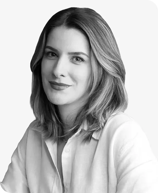 Studio portrait of a woman with medium-length hair, wearing a light shirt and smiling.